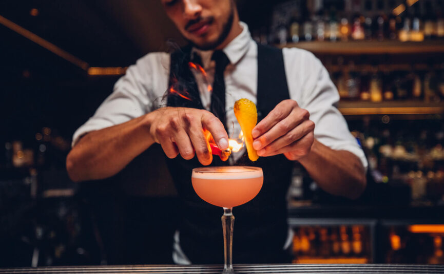 A bartender crafting a cocktail.