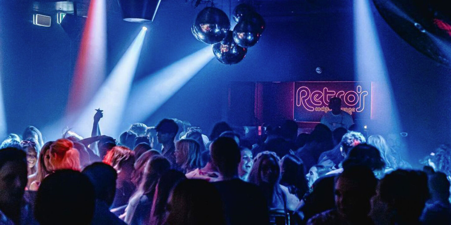 DJ playing in front of a packed dancefloor at Retro's Brisbane