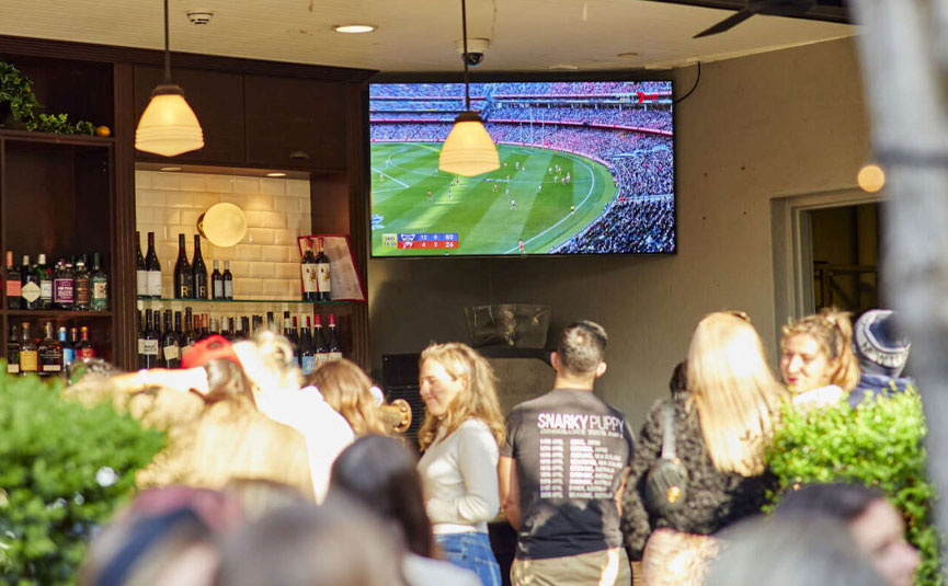 Punters watching AFL in a bar
