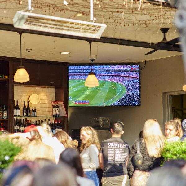 Pub Patrons gathered around watching the AFL