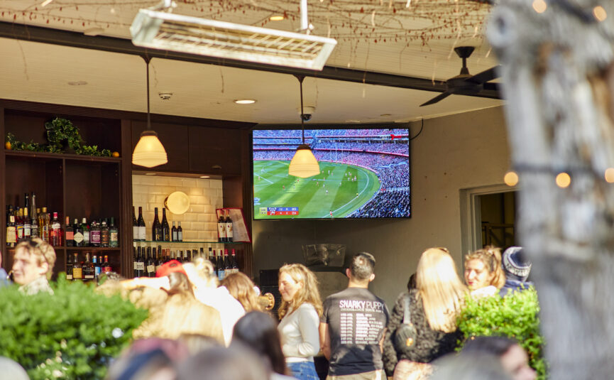 Pub Patrons gathered around watching the AFL