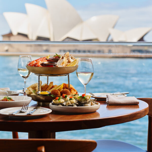 A waterfront dining area with the Sydney Opera House in the background.
