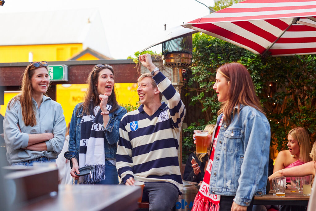 Group of AFL fans at a pub cheering