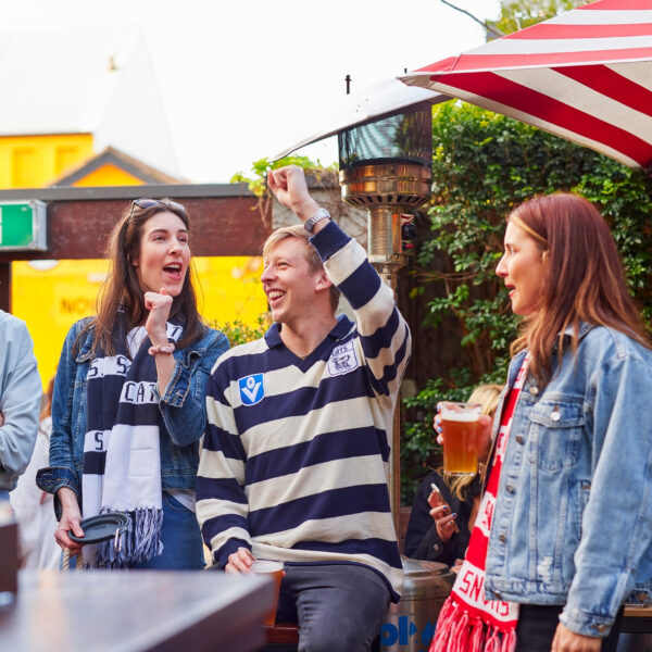 Group of AFL fans at a pub cheering
